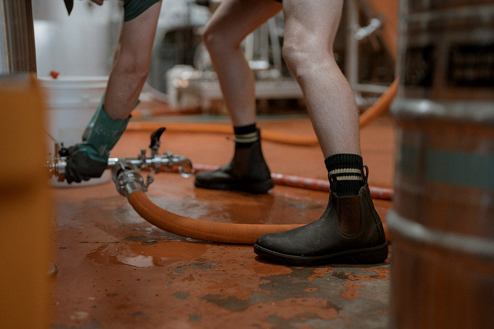 Person working with hoses and equipment on a concrete floor