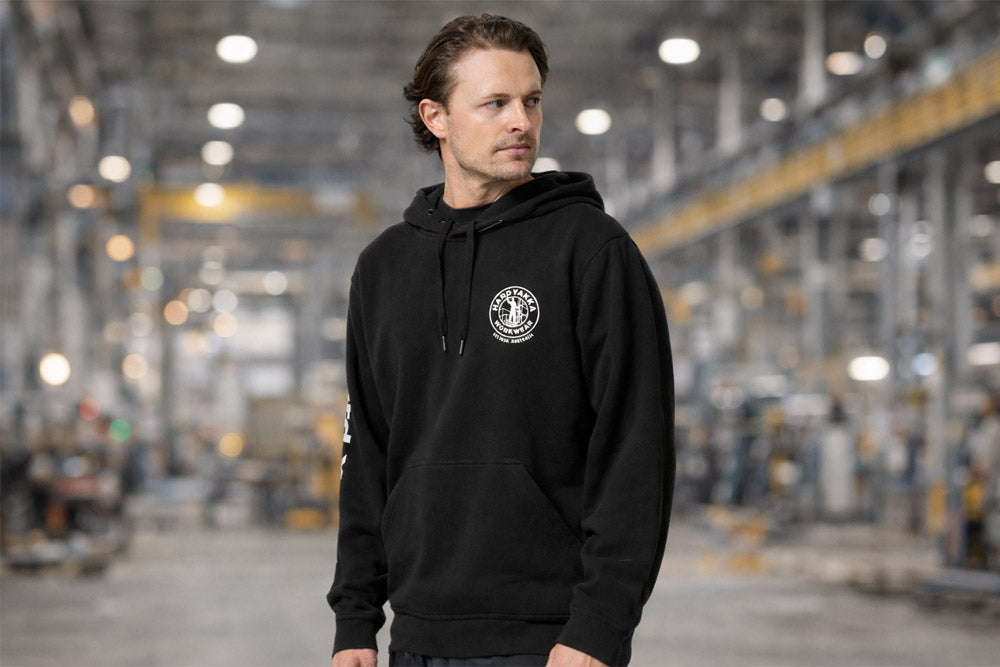 Man in black sweatshirt standing in industrial workplace