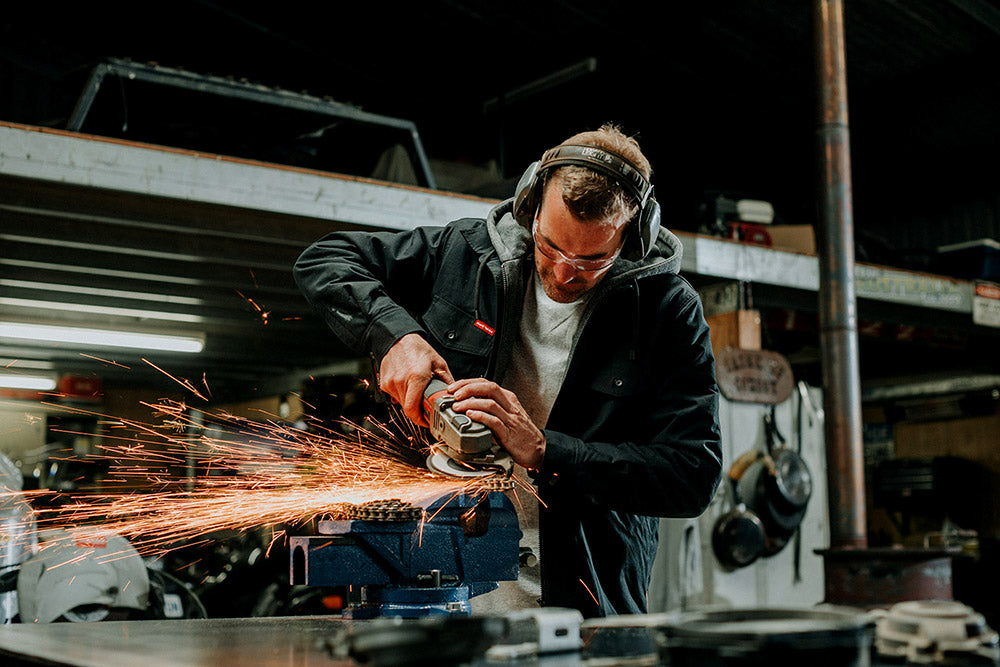 Person using a grinder with sparks in a workshop setting
