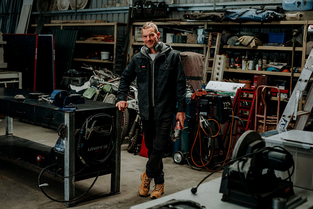 Man standing in a workshop with tools and equipment around