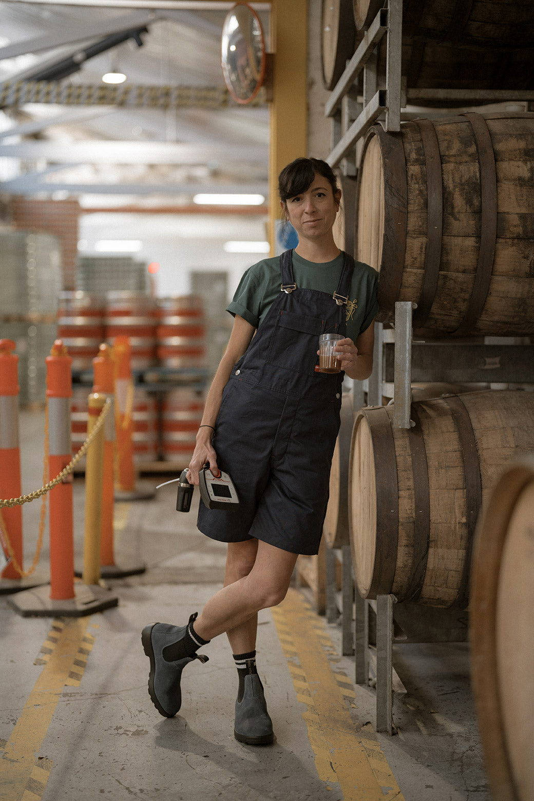 Person in a warehouse with barrels and safety cones