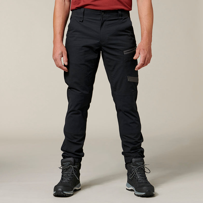 Person wearing black pants and hiking boots on a beige background