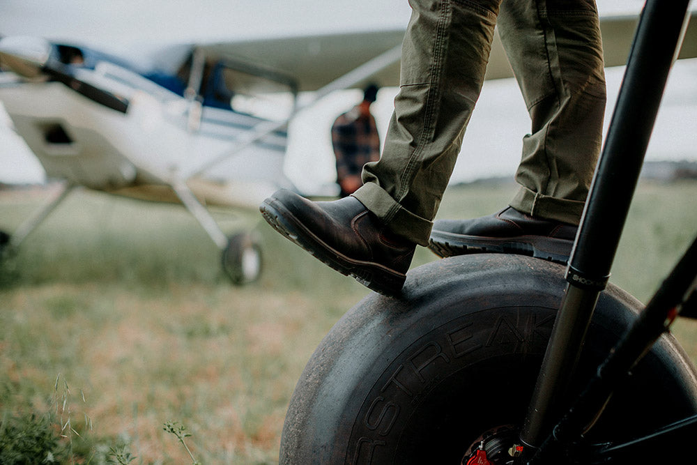 Person standing on a propeller of a small airplane